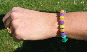 Armband av UV-pärlor på arm.