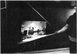 Bild med lång slutartid som visar hur man genom att vifta med en pinne i ett ljusflöde från en diabildsprojektor kan framkalla en bild i luften. Foto.