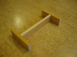 Ett H-format stöd i trä för att plankan ska ligga stabilt. Foto.