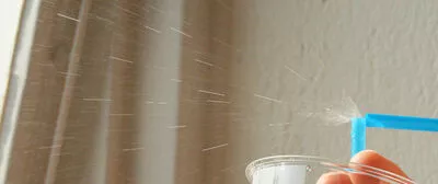 Bilden visar hur vätska sprutar ut ur ett avbrutet sugrör. Foto.